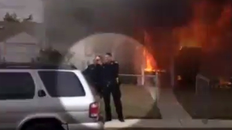 El "asqueroso" 'selfie' de dos policías frente a una casa en llamas causa indignación 