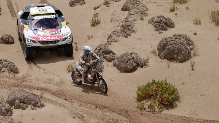 Motorista francés ayuda a participante rusa a levantar su moto en el rally Dakar-2017