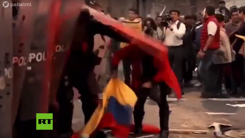 Un policía de Ecuador golpea a una mujer que intentaba recoger la bandera nacional del piso (VIDEO)