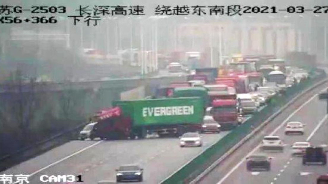 FOTO: Un camión con un contenedor con el logo de Evergreen bloquea una autopista en China, recreando el atasco del canal de Suez