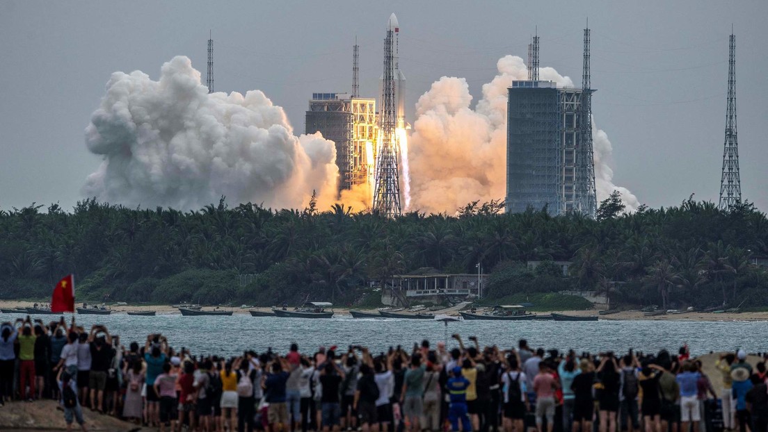 Decenas de personas observan desde una playa cómo el cohete Long March-5B Y2 despega del centro de lanzamiento espacial de Wenchang, en Hainan, China. 29 de abril de 2021.