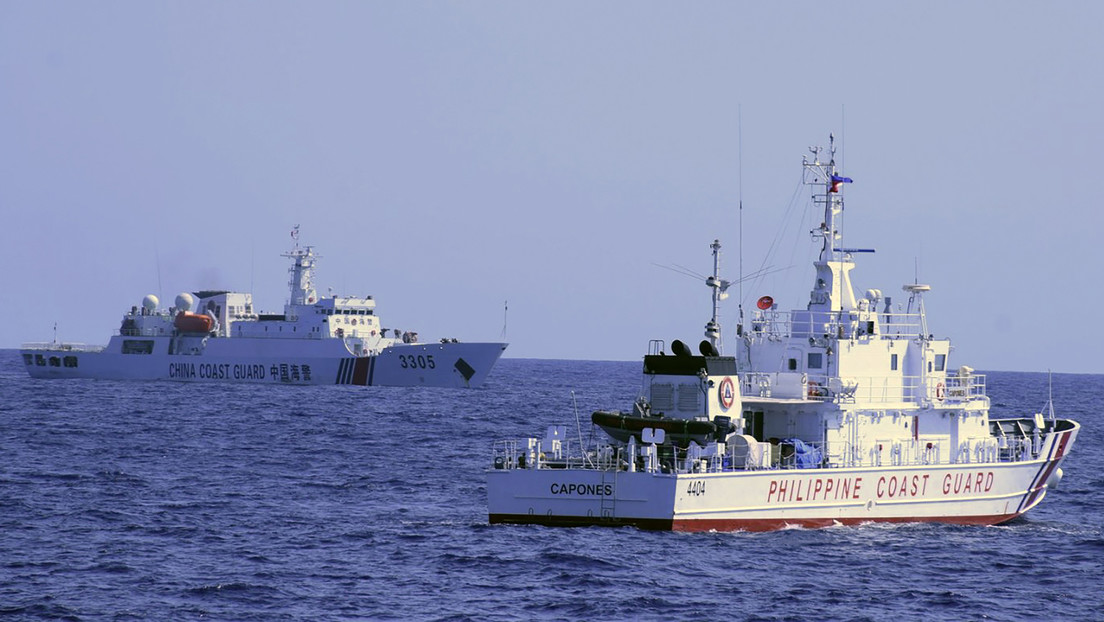 Un barco de la Guardia Costera de China navega cerca de un buque de las autoridades de Filipinas.