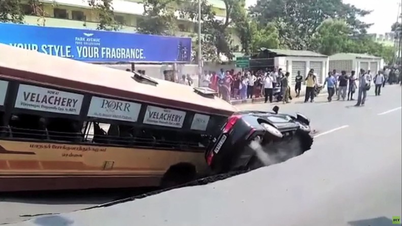 Indien: Bus und Auto von Erdloch verschluckt