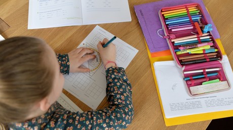 Vater trainiert Hund auf Hausaufgabenkontrolle seiner Tochter