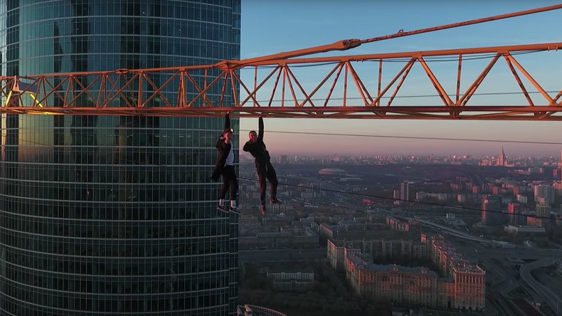 Just crane crazy! Fearless daredevils hang over Moscow with one arm (DRONE VIDEO)