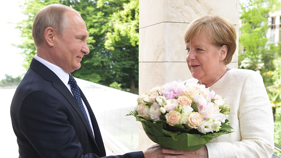 Flower power: Putin greets visiting Merkel with bouquet (VIDEO)