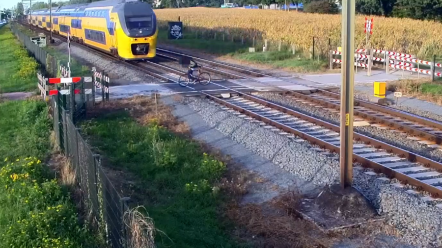 Split-second from disaster: Cyclist cheats death after failing to spot oncoming train (VIDEO)