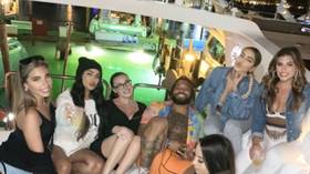 Social distancing? Grinning NFL star Derrius Guice takes flak after cozying up to six models on Miami boat