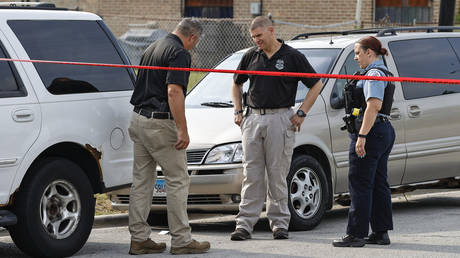 Law enforcement officers investigate a crime scene near the border between the Morgan Park and West Pullman neighborhoods on July 7, 2021 in Chicago, Illinois. © Kamil Krzaczynski/Getty Images