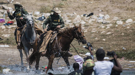 U.S. Customs and Border Protection mounted officers attempt to contain migrants as they cross the Rio Grande from Ciudad Acuña, Mexico, into Del Rio, Texas, Sunday, Sept. 19, 2021. © AP Photo/Felix Marquez