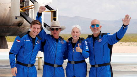 Oliver Damen, Jeff Bezos, Wally Funk, and Mark Bezos pose in spacesuits before Blue Origin’s inaugural flight near Van Horn, Texas, US, July 2021. © Reuters/Joe Skipper
