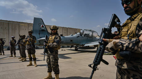 Taliban fighters guarding their new US-made aircraft after American troops leave © Getty Images / Marcus Yam