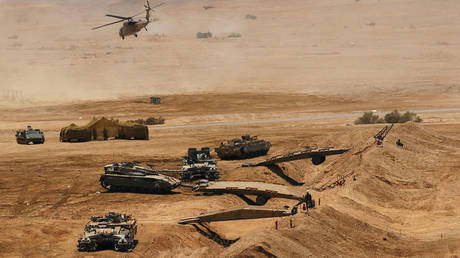 In this handout photo distributed by the Israel Defense Forces (IDF) helicopters and tanks are mobilized as the Israeli army takes part in a military manoeuvre to conquer a Syrian outpost. © IDF via Getty Images