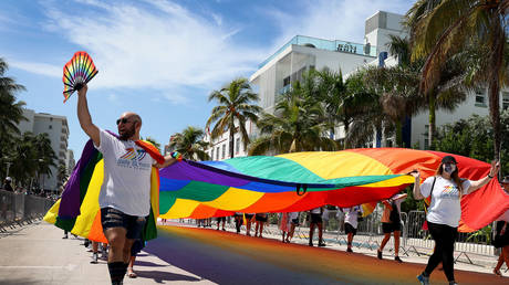 People carry a rainbow flag as they participate in the Miami Beach Pride Parade in Miami Beach, Florida