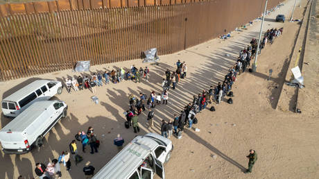 US Border Patrol agents take lines of immigrants into custody at the US-Mexico border in Yuma, Arizona, December 7, 2021 © Getty Images / John Moore