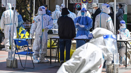 Healthcare workers and volunteers are pictured in a residential compound where mass Covid-19 testing is being conducted on April 4, 2022, Shanghai, China