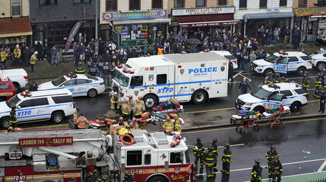 Emergency personnel gather at the entrance to a subway stop in the Brooklyn borough of New York, April 12, 2022