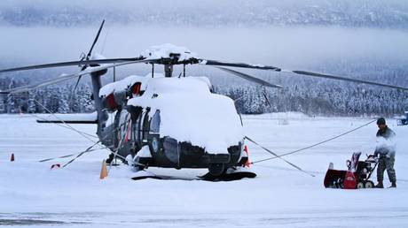 FILE PHOTO: Alaska Army National Guardsman clears snow around a UH-60 Black Hawk helicopter at Joint Base Elmendorf-Richardson