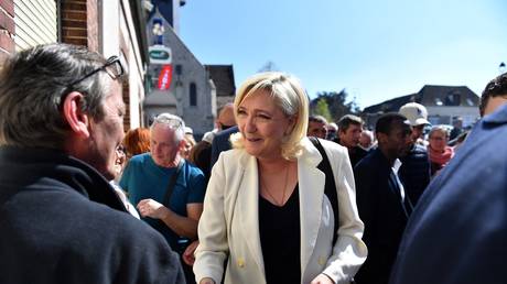 The French National Rally party’s presidential candidate, Marine Le Pen, shakes hands with a member of the public during a campaign visit on April 16, 2022, Saint-Remy-sur-Avre, France