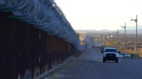 PHOTO DE FICHIER.  Un véhicule de la US Border Patrol roule le long de la barrière frontalière à la frontière américano-mexicaine.