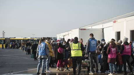 Refugees from Ukraine queue at a newly built arrival center on the tarmac of the former Tegel airport in Berlin, Germany, March 20, 2022 © AP / Steffi Loos)