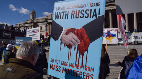 FILE PHOTO: A protester holds a placard calling for a ban on all international trade with Russia, during the pro-Ukraine rally in Trafalgar Square. © Vuk Valcic / SOPA Images / LightRocket via Getty Images