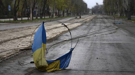 A Ukrainian flag is seen on the ground in an area controlled by Russian-backed forces in Mariupol, on April 18, 2022.