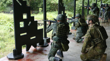 FILE PHOTO: An Australian soldier (R) watches as Philippine Marines fire at targets during a training demonstration at the Gregorio Lim Marine Base near Manila, Philippines, December 18, 2017.