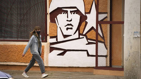 FILE PHOTO. A woman walks past the Operational Group of Russian Forces headquarters in Tiraspol.