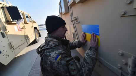 文件图片：一名军人将乌克兰国旗贴在美国制造的悍马装甲车上。  © 法新社 / 谢尔盖·苏平斯基