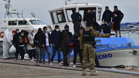 FILE PHOTO: Migrants disembark from a vessel after an operation by the Greek Coast guard at the port of Katakolo, Greece, November 3, 2020.