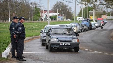 Moldovan police officers watch cars queuing to enter the self-proclaimed Moldovan Republic of Transnistria. © AFP / Aniel Mihailescu