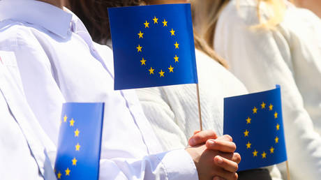 FILE PHOTO: People hold EU flags in Krakow, Poland, May 1, 2022. © Beata Zawrzel / Nur Photo / Getty Images