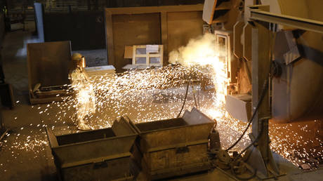 Un ouvrier nettoie un bac en acier dans une aciérie en Allemagne.  © AFP / Morris Mac Matzen