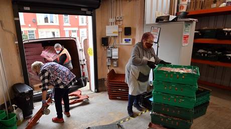 FILE PHOTO: Volunteers sort food at Blackpool Food Bank in Blackpool, Britain, March 9, 2021 © AFP / Paul Ellis