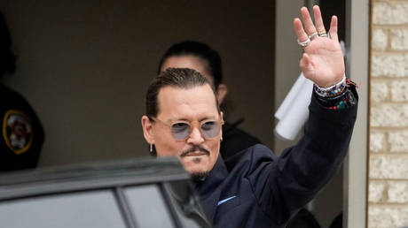 Actor Johnny Depp waves to fans as he departs the Fairfax County Courthouse on May 27, 2022 in Fairfax, Virginia.