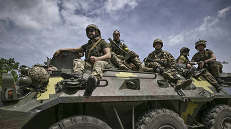 Ukrainian troops sit on an armored vehicle as they move back from the front line on June 1, 2022, near Slovyansk, Ukraine