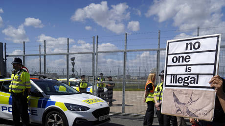 A protester holds up a sign outside Brook House Immigration Removal Centre on June 12, 2022, London, UK