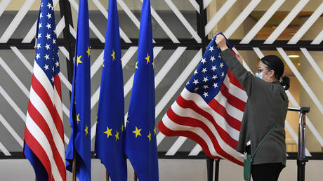 A member of protocol adjusts US and EU flags prior to the arrival of ministers at the European Council building in Brussels, Belgium, March 4, 2022 © AP / Geert Vanden Wijngaert