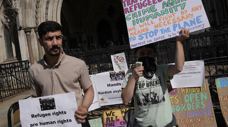 Protesters stand outside the High Court while a ruling on Rwanda deportation flights takes place in London, Britain, June 13, 2022 © AP / Alastair Grant