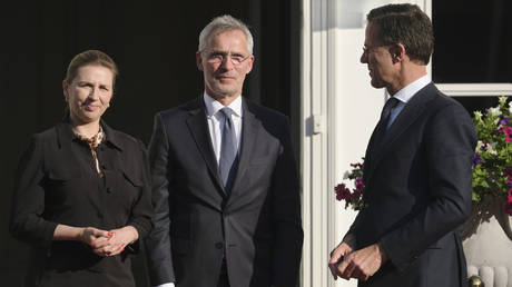 NATO Secretary General Jens Stoltenberg (center) is welcomed by Dutch PM Mark Rutte and Danish PM Mette Frederiksen in The Hague, Netherlands, June 14, 2022.