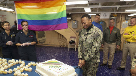 FILE PHOTO: Intelligence Specialist Seaman Jalen Williams cuts a cake during a Pride Month celebration on the mess decks of the amphibious assault ship USS Tripoli (LHA 7). © US Navy / Christopher Sypert