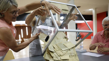 Volunteers emptying a ballot box at a polling station in Strasbourg, France, June 19, 2022. © AP Photo / Jean-Francois Badias