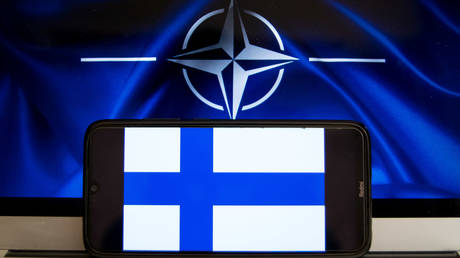 FILE PHOTO. A flag of Finland displayed on a smartphone screen with flag of NATO in the background. ©Nikolas Kokovlis / NurPhoto via Getty Images