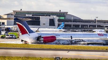 A Red Air plane that caught fire after the front landing gear collapsed upon landing is seen at Miami International Airport, June 21, 2022