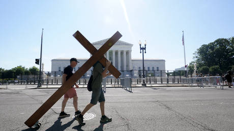 A person carries a cross outside the Supreme Court in Washington, DC, June 25, 2022 © AP / Steve Helber