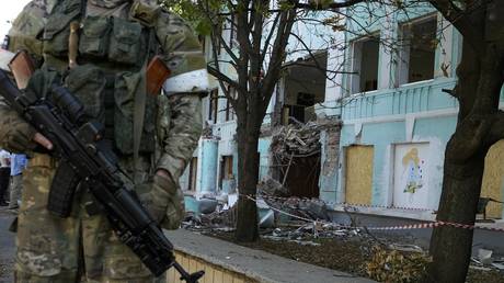 A Russian soldier stands next to a school building shelled by Ukrainian forces in Donetsk, Donetsk People's Republic, June 13, 2022 © AP