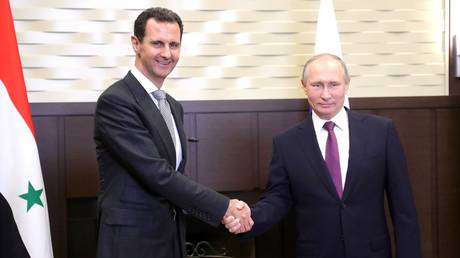 FILE PHOTO. Russian President Vladimir Putin (R) shakes hands with Syrian President Bashar al-Assad (R).
