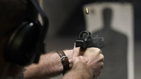 A man fires a pistol at an indoor shooting range during a qualification course to renew his concealed carry handgun permit, in Roseville, California, July 1, 2022.