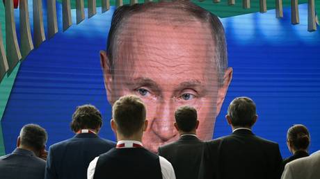 Participants gather near a screen showing Russian President Vladimir Putin delivering a speech during a plenary session of the 25th St. Petersburg International Economic Forum (SPIEF) in Saint Petersburg, Russia. © Sputnik